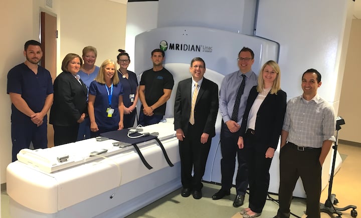 Henry Ford Hospital's ViewRay MRIdian linear accelerator system allows real-time MRI-guided radiotherapy. Shown is the support staff for this system. In the center of the photo is Benjamin Movsas, M.D., chair of radiation oncology at Henry Ford Cancer Institute. Second from the right is Carrie Glide-Hurst, Ph.D., director of translational research, radiation oncology.