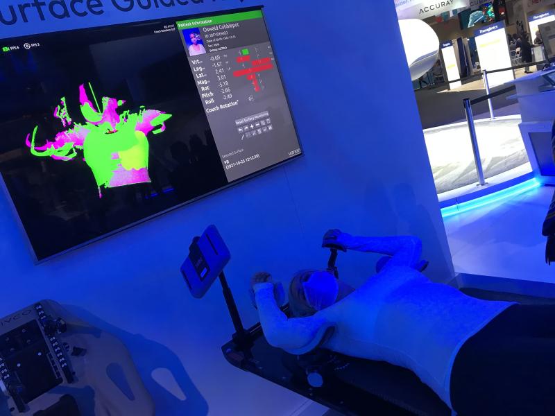 This is the Varian Identify surface guided radiation therapy patient positioning system demonstrated at ASTRO 2021 last week. It uses light projected from three different angles to triangulate the exact position of the surface of the patient using cameras. This is matched with treatment plan CT scans to register the patient exactly on the table. It also offers real-time color coded identification of areas that are not in the correct position on an overhead screen so adjustments can be made. #ASTRO21