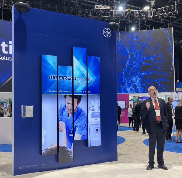 The exhibit hall at RSNA 2022 was educational and exciting with attendees able to learn about new innovations from radiology leaders like Bayer, shown here as a representative explains its MEDRAD Centargo Injection System.