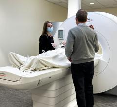 Orlando Simonetti (right) works with MRI technologist Heather Hermiller to operate a new FDA-approved MRI machine that he helped develop. The machine has a lower magnetic field and larger patient opening, expanding access to patients who were previously unable to undergo MRI.