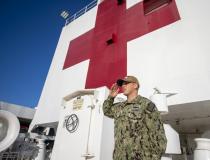 Lt. Ronald Silver, from Ontario, Calif., renders a hand salute during morning colors aboard the hospital ship USNS Mercy in the Port of Los Angeles to help with local efforts to contain and treat COVID-19 patients. U.S. Navy photo by Mass Communication Specialist 2nd Class Abigayle Lutz.